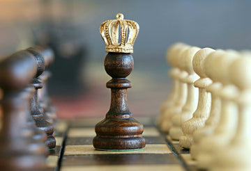 chess pawn with crown with other pawns on both sides