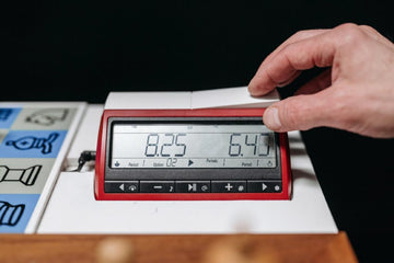 chess clock with a hand on one side