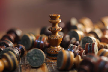 handmade chess pieces strewn about a board