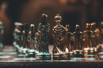 a shadowed chess set with metallic pieces of unique design