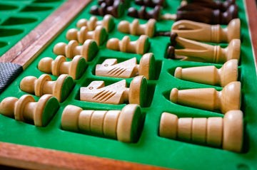 Selective focus shot of a set of wooden chess pieces in a green box