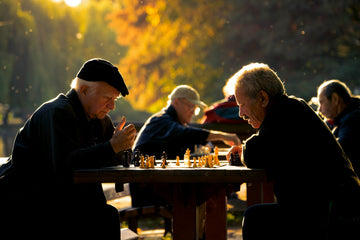 Two people playing chess outside