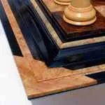 The corner of a black brown and red luxury wooden chess board